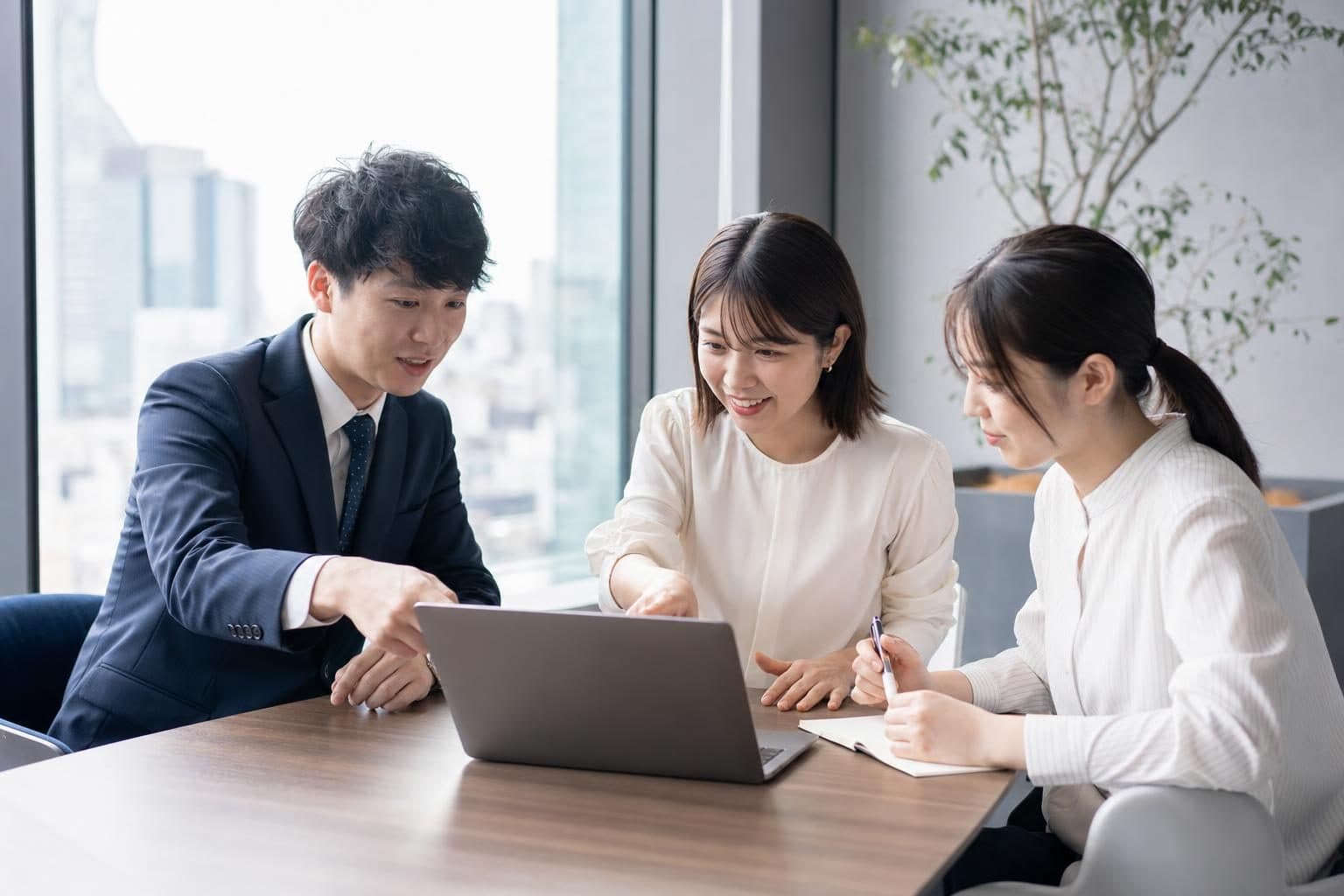 チームでノートPCを囲んで議論する様子